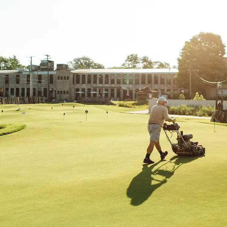 Man Mowing a Golf Course